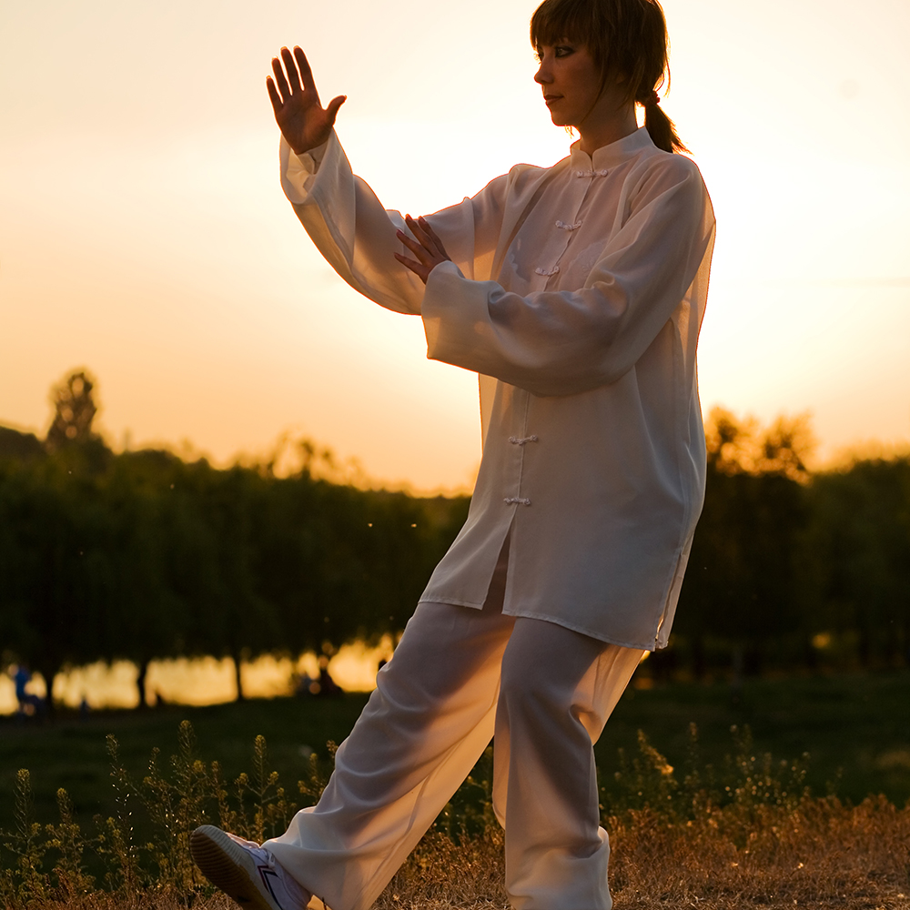 woman doing qigong with arms raised