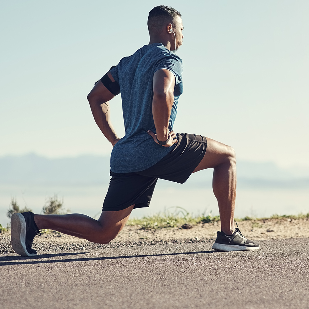 Shot of a young handsome man doing lunges outdoors