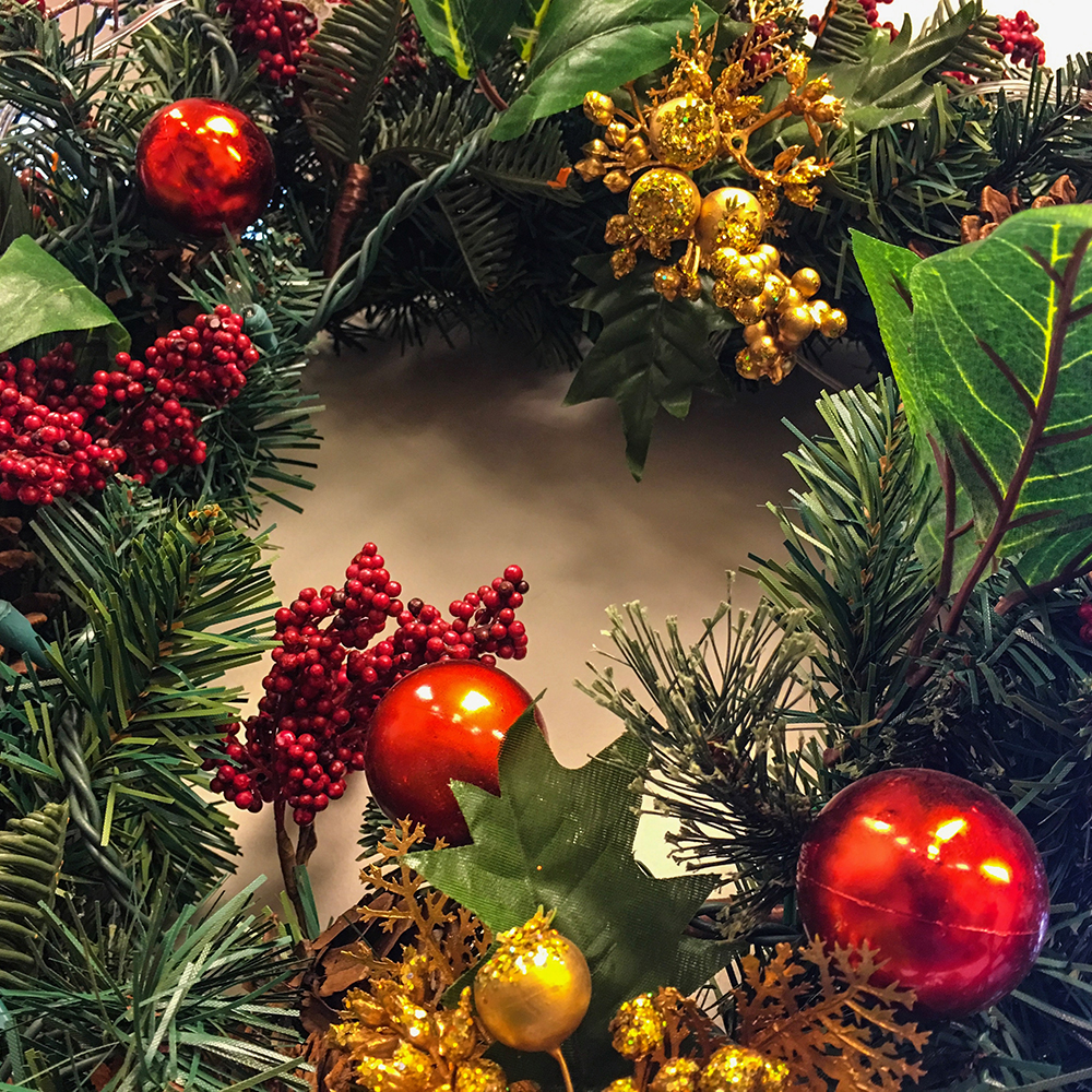 Christmas Holiday Wreath Background card with copy space or room for message with bright ornaments and red, green, and gold colors nature berry theme to celebrate the holiday season