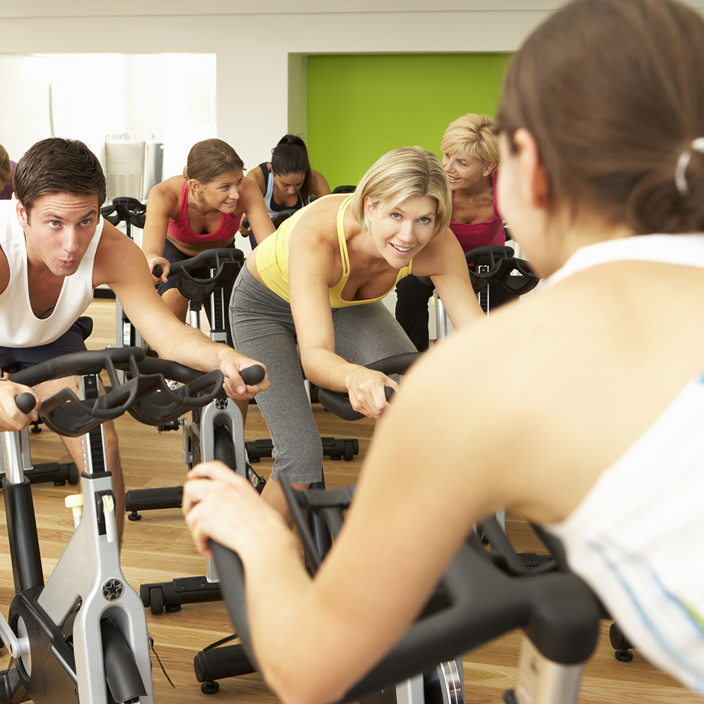 Group Taking Part In Spinning Class In Gym