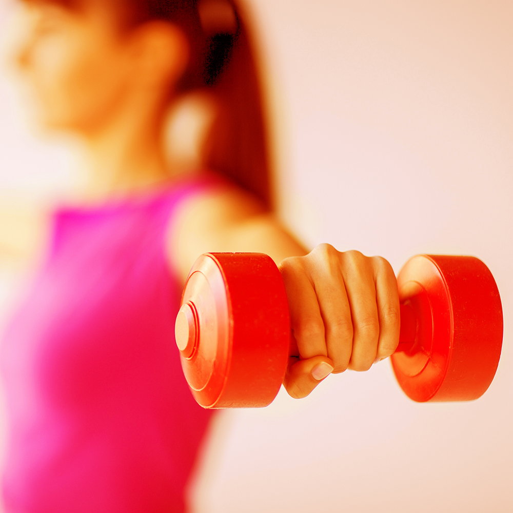 sport and recreation concept - sporty woman hands with light red dumbbells